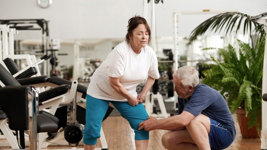 Woman with knee pain and a man helping her